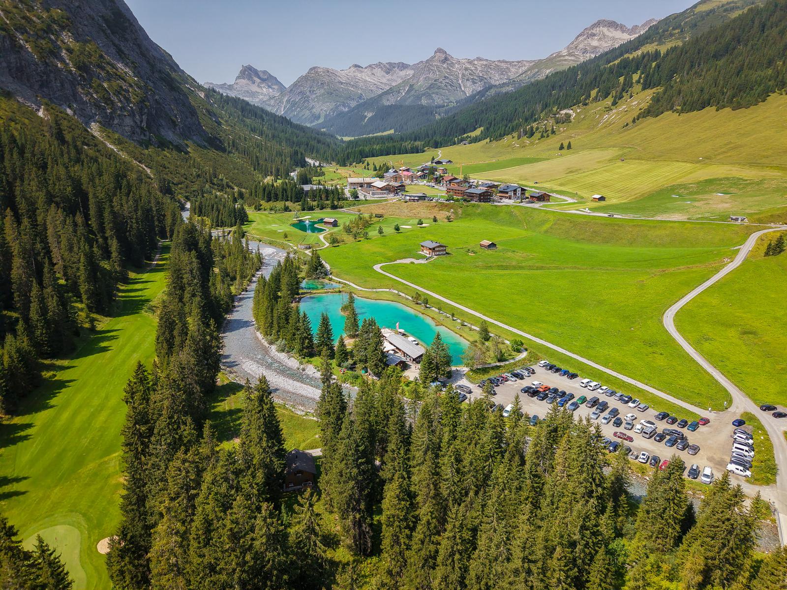 Parkplatz und Zufahrtsstraße am Fischteich im alpinen Tal